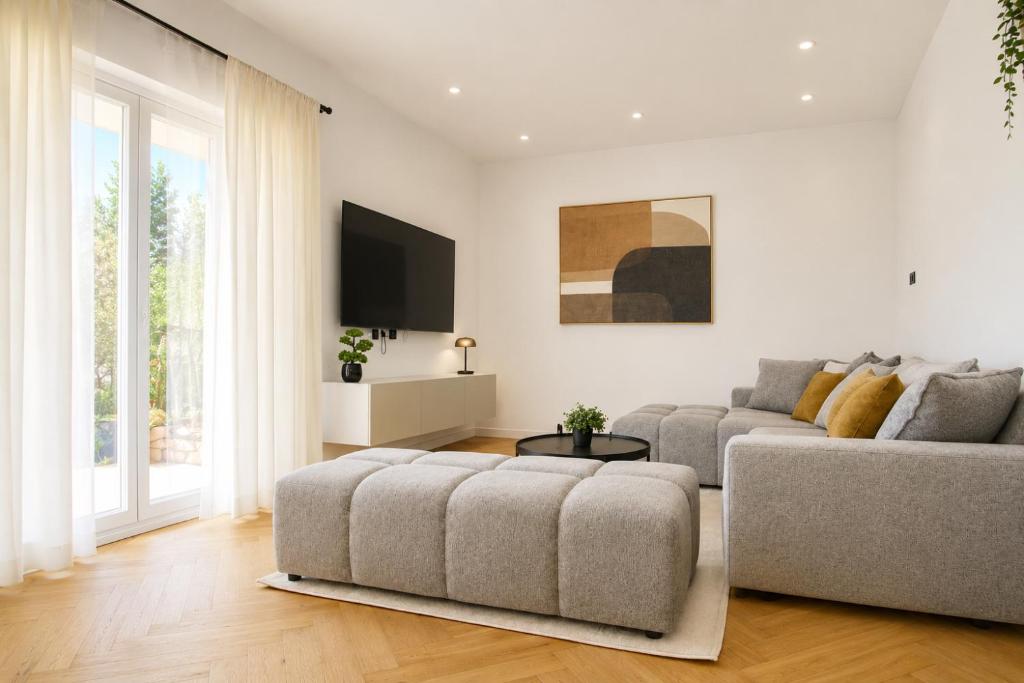 a living room with a couch and a tv at Luma Luxury Apartment - 5 min Walk to the Beach in Sutomišćica
