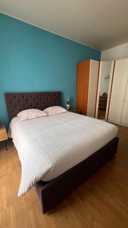 a large bed in a bedroom with a blue wall at Eden Riviera in Beausoleil