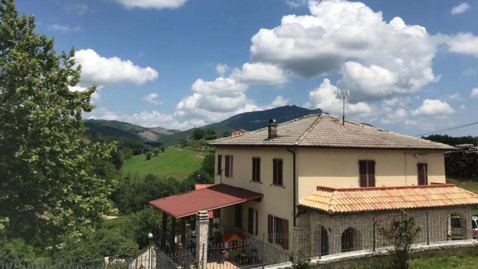 Ein Haus auf einem Hügel mit Bergen im Hintergrund in der Unterkunft Dimora Ferretti in Venarotta