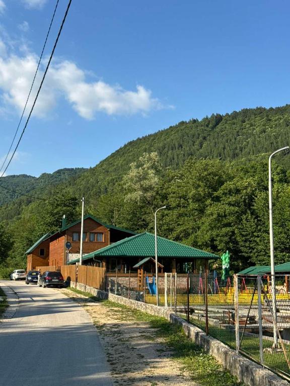 a building on the side of a road next to a mountain at GUZIJAN seosko domaćinstvo in Šipovo