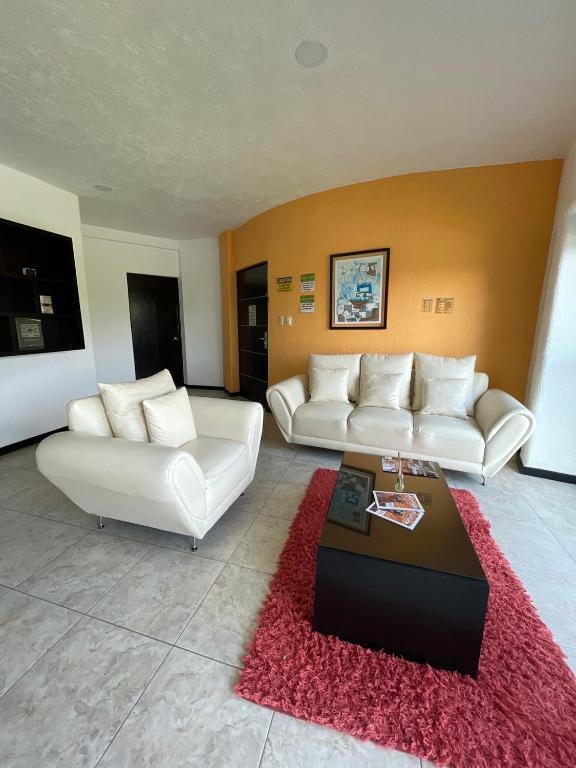 a living room with two white couches and a red rug at Apartment with Pool, Gym & A/C in Querétaro