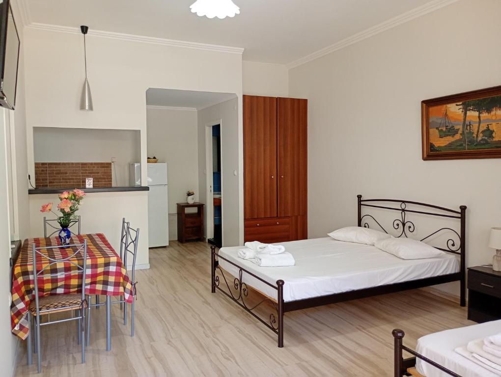 a bedroom with a bed and a table and chairs at Lily's Studios in Nikiana