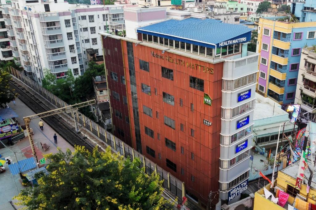 a tall red building in a city with buildings at NHM Stays in Garui