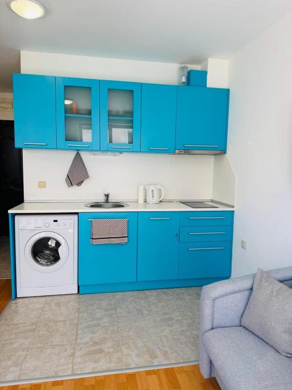 a kitchen with blue cabinets and a washing machine at Byla Central Studio in Byala