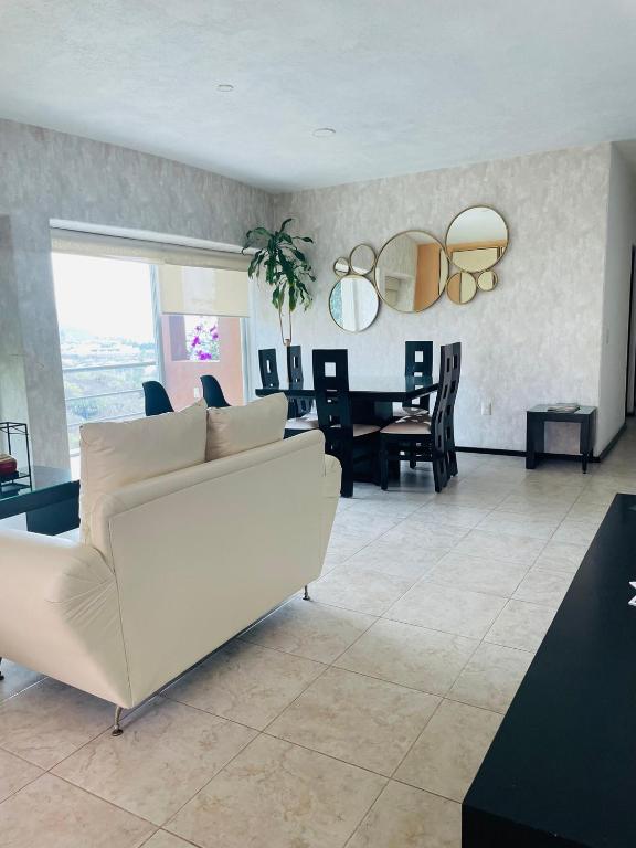 a living room with a white couch and a table at Apartment with Pool, Gym & A/C Suite in Querétaro