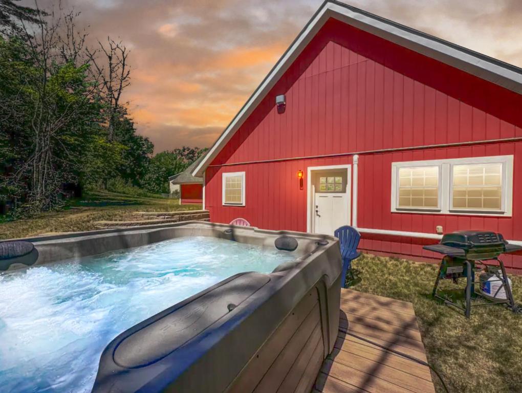 a swimming pool in front of a red house at White Mountain Dream Cabin in Fryeburg