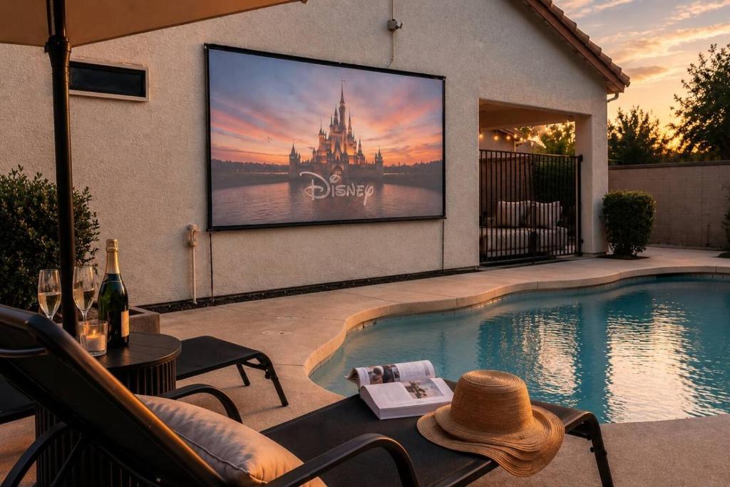 a large screen tv is on a wall by a swimming pool at Desert Disconnect Outdoor Cinema and Pool in Mesa
