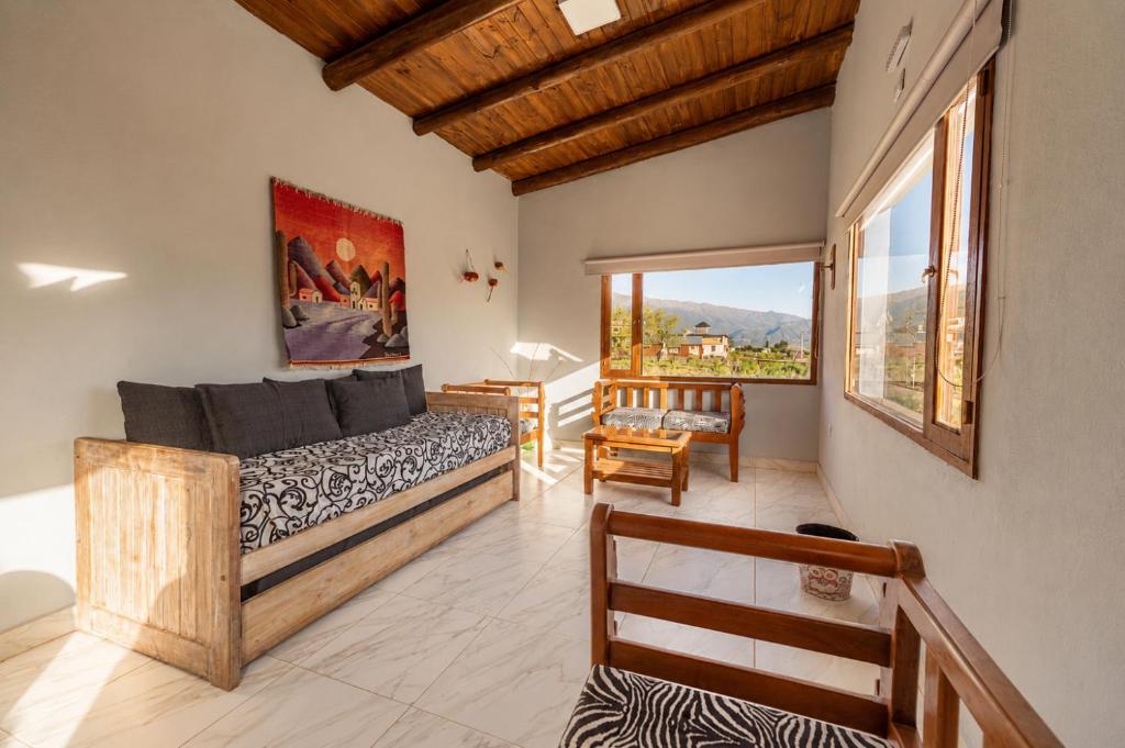 a bedroom with a large bed and a balcony at Amplios Departamentos con Vistas a los cerros - Patio, Asador y Pileta in Tafí del Valle