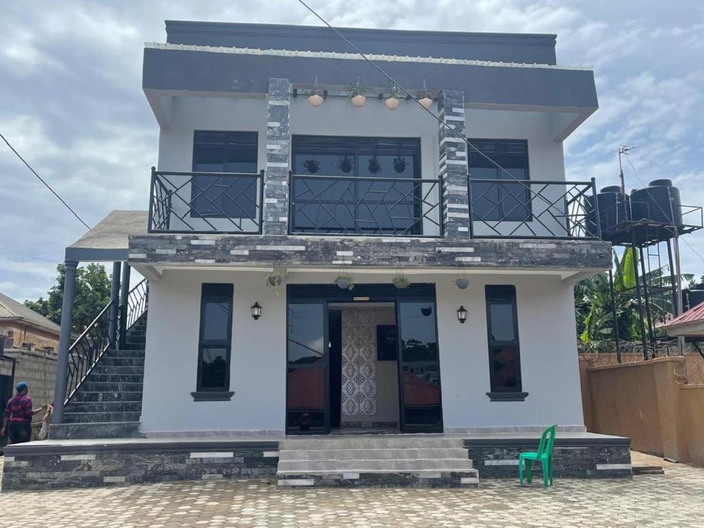 a white house with a green chair in front of it at LILY'S spa and accomodations in Mukono