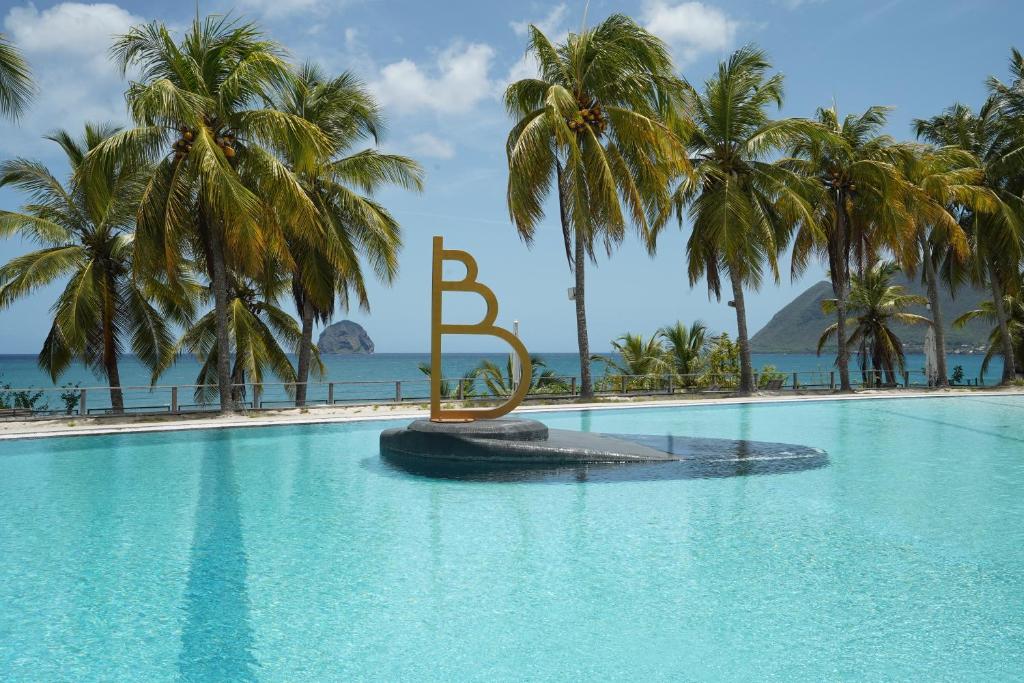 a large swimming pool with a large letter b in the middle at Suite Blue Diamond vue mer in Le Diamant