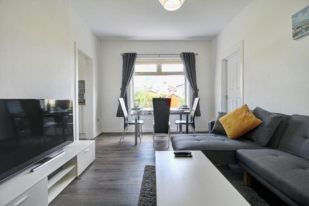 a living room with a couch and a table at Kingspark Apartment Apartment in Glasgow