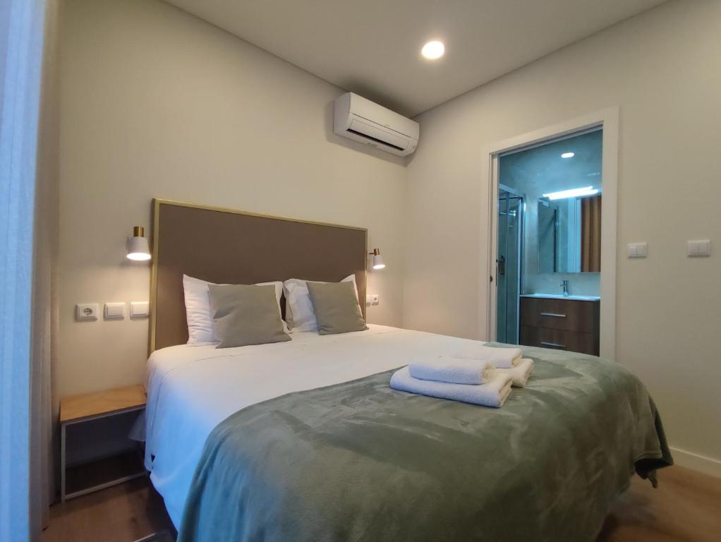 a bedroom with a bed with two towels on it at Barcelos Habadia da Loja in Lijó