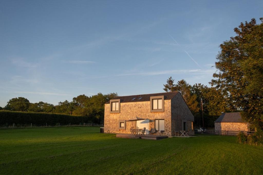 a brick house in a field with a grassy yard at Brook Lodge Farm in Uckfield
