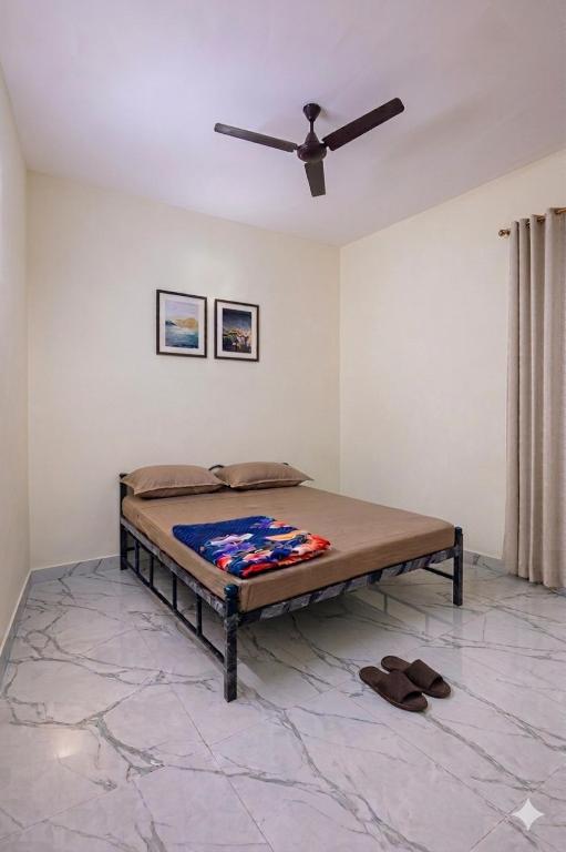a bed in a room with a ceiling fan at Forum Stay in Mysore
