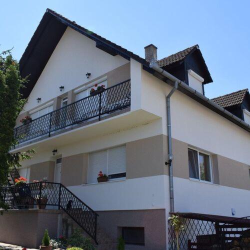 a large white building with a balcony with flowers on it at Andrea Apartman in Siófok