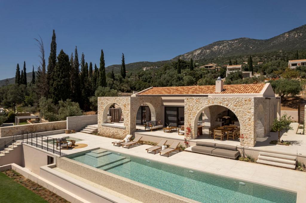 a villa with a swimming pool and a house at Kerami Kefalonia in Kefallonia