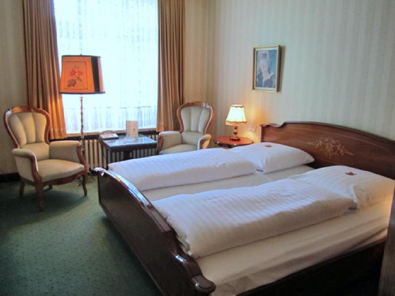 1 dormitorio con 1 cama, 2 sillas y ventana en Hotel Stephan en Hamburgo