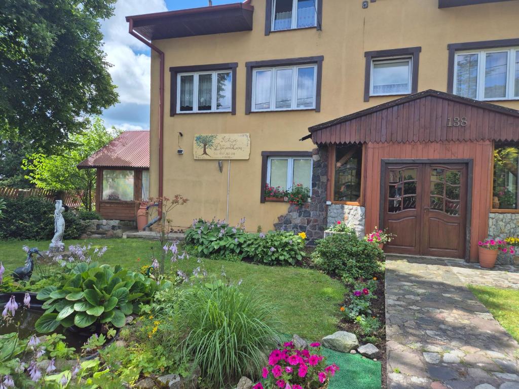 a house with a garden in front of it at Dom pod lipą in Łeba