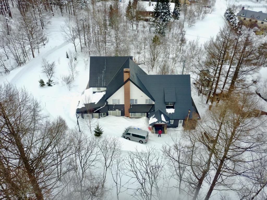 uma vista aérea de uma casa na neve em White Rose Inn em Hachimantai