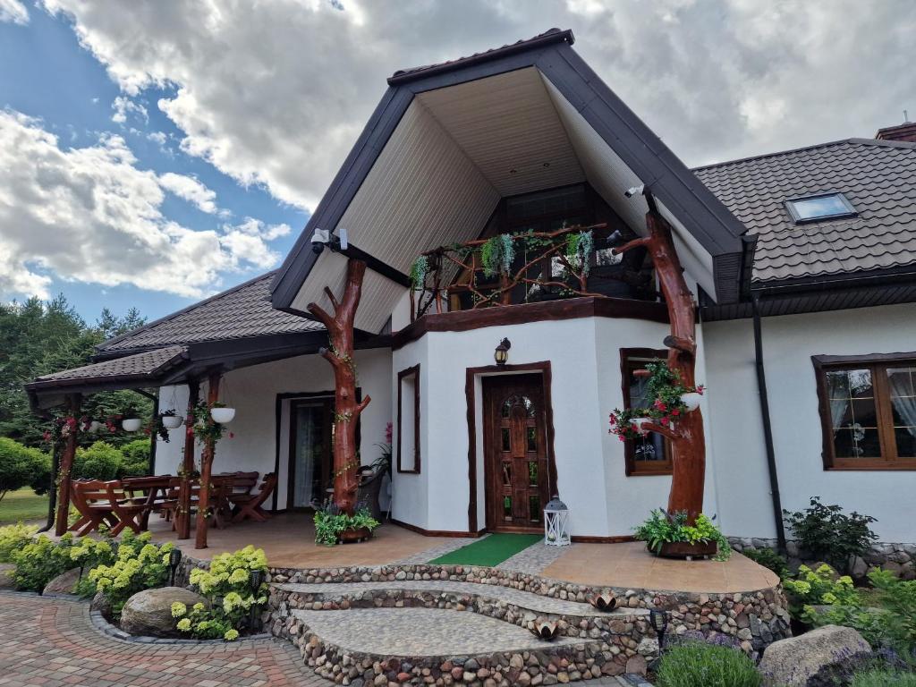 a small white house with a patio at Bylew Zacisze in Licheń Stary