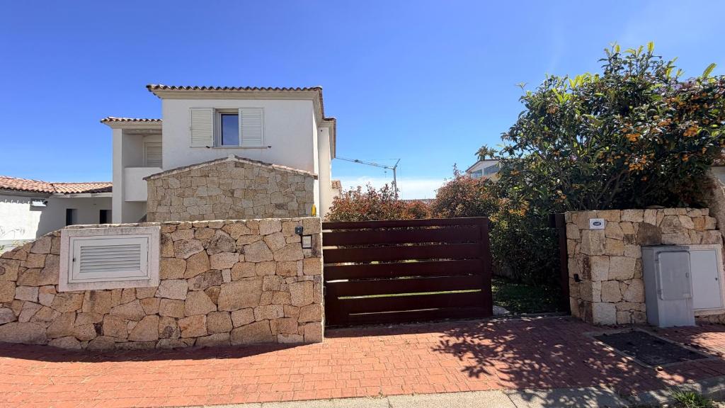 a gate in front of a house with a stone wall at RH1 and RH2 - PuntoCasaBudoni in Budoni
