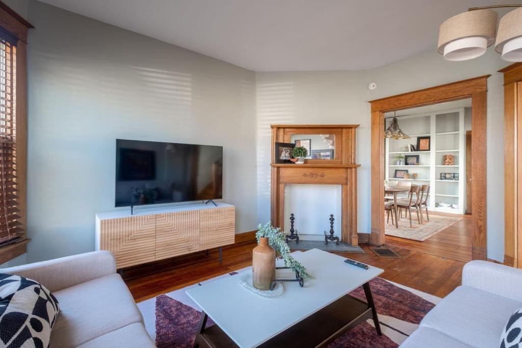 a living room with a tv and a couch and a table at Robin's Egg, Private Downtown, Pet-Friendly Gem in Columbus