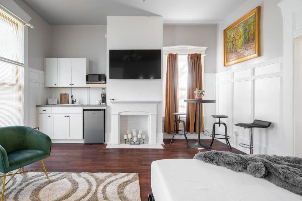 a living room with a white couch and a kitchen at Walk/ Bike everywhere from this Historic Chic Studio in Columbus