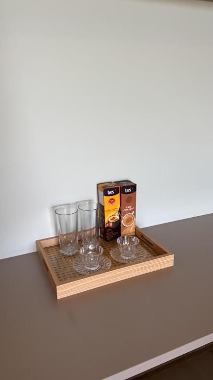 a wooden shelf with glasses and a box of alcohol at Apartamento 313 Bobz Concept in Cajueiro