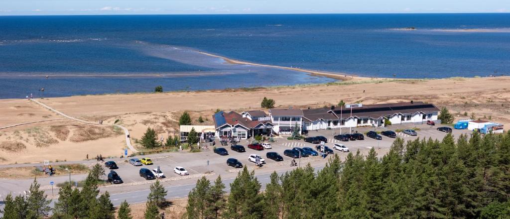 a group of cars parked in a parking lot near the ocean at Hotel Lokkilinna in Kalajoki