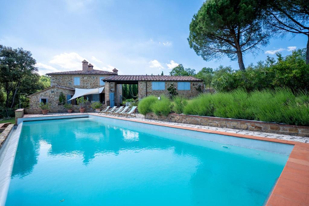 a swimming pool in front of a house at Private Tuscan Villa with Infinity Pool & Views in Vagliagli