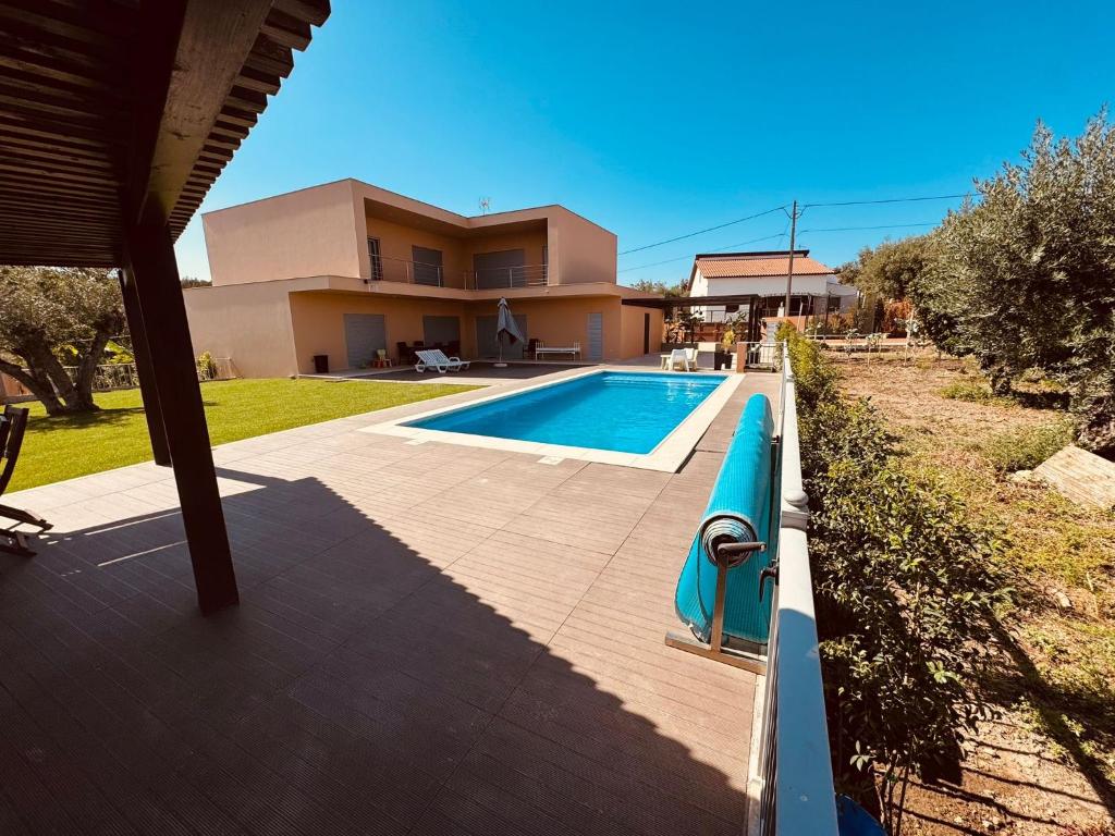 a swimming pool in front of a house at L'École Villa Nature in Abrantes
