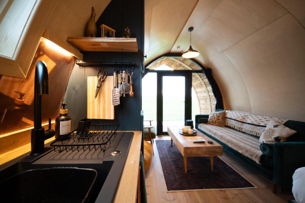 a kitchen with a stove and a couch in a room at Hillend by Wigwam Holidays in Todmorden