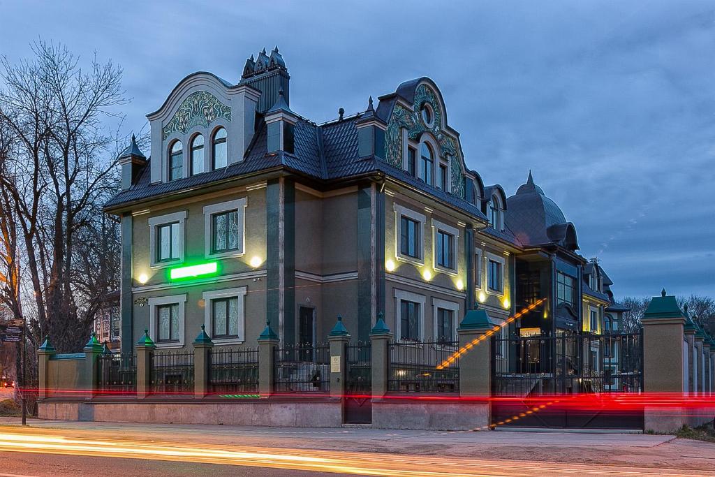 duży budynek z zielonym znakiem na nim w obiekcie Barskiye Polati Hotel w mieście Siergijew Posad