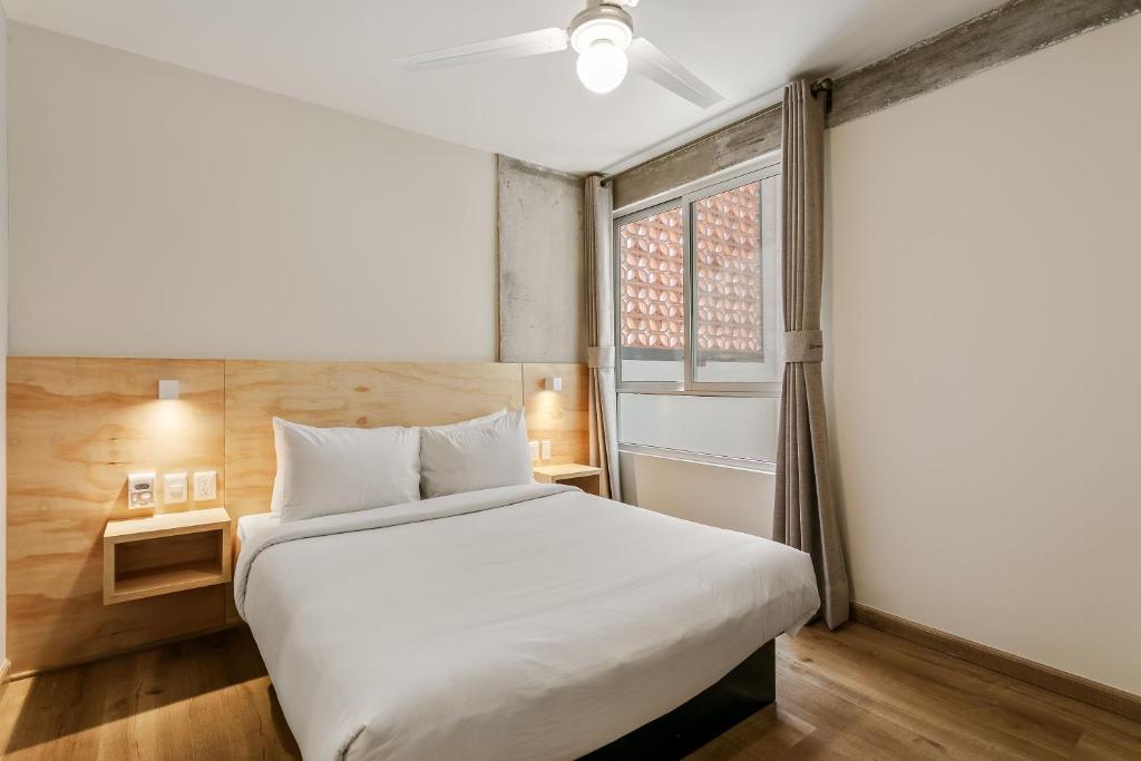 a bedroom with a white bed and a window at El Pocito by Homirent in El Jacal