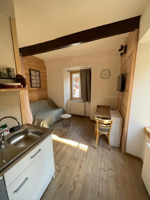 a kitchen and living room with a sink and a table at Gallice Bey in Briançon