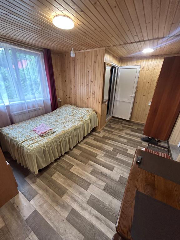 a bedroom with a bed in a wooden room at Смарт-Квартира in Yaremche