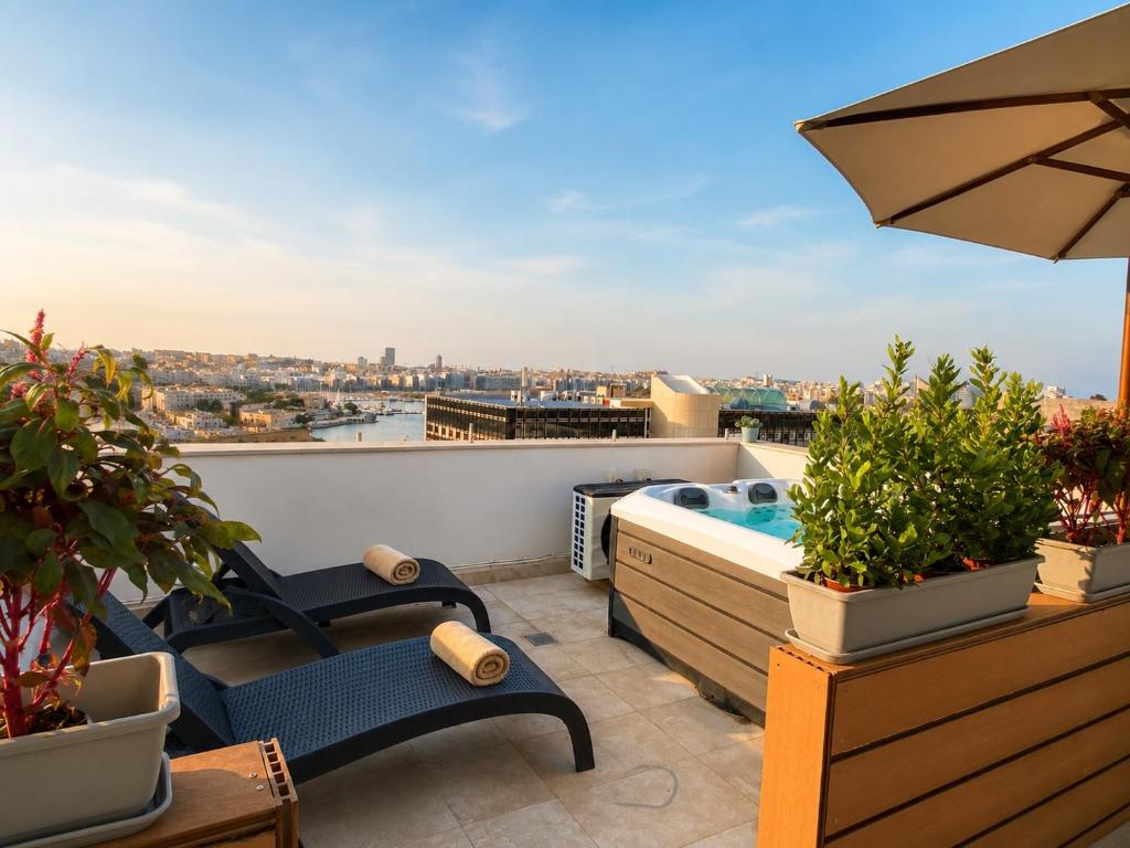a rooftop patio with a hot tub and potted plants at Tritoni Valletta Boutique Hotel in Il-Furjana