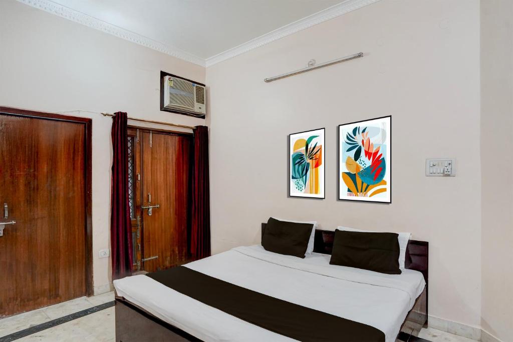 a bedroom with a bed and a wooden door at Hotel O Hotel Brijwasi in Lucknow