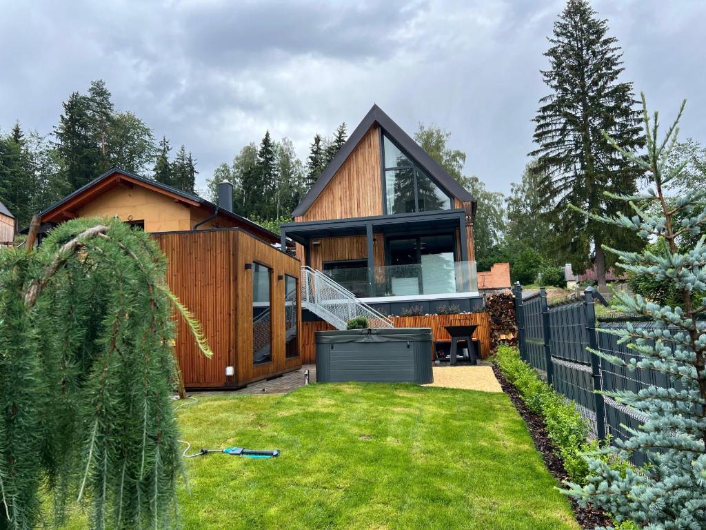 a wooden house with a garden in front of it at Lipno View Jenišov in Jenišov