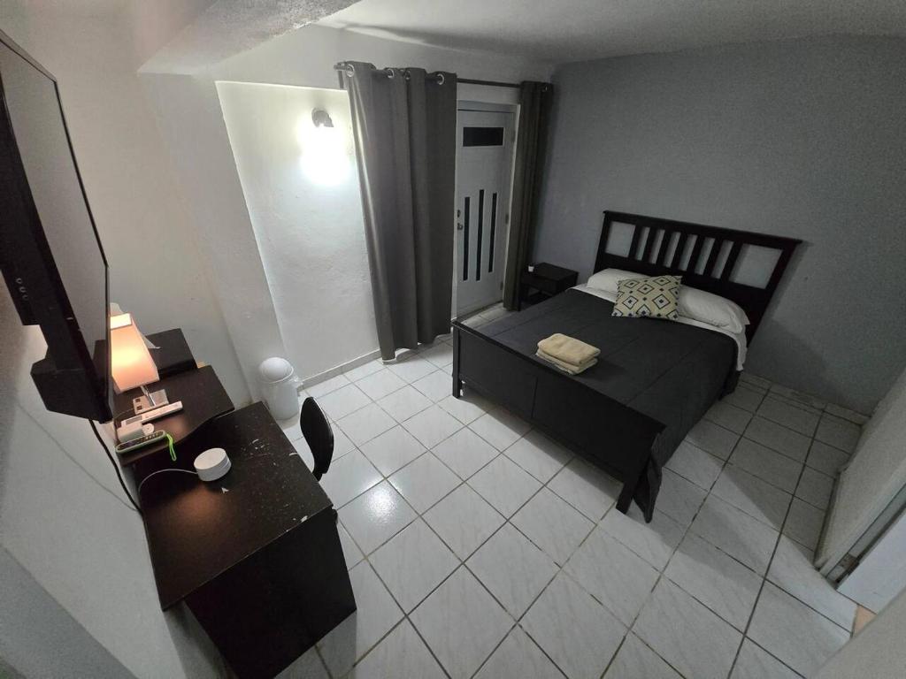 a small bedroom with a bed and a table at Above the Plaza 6 (with A/C) in Rincon