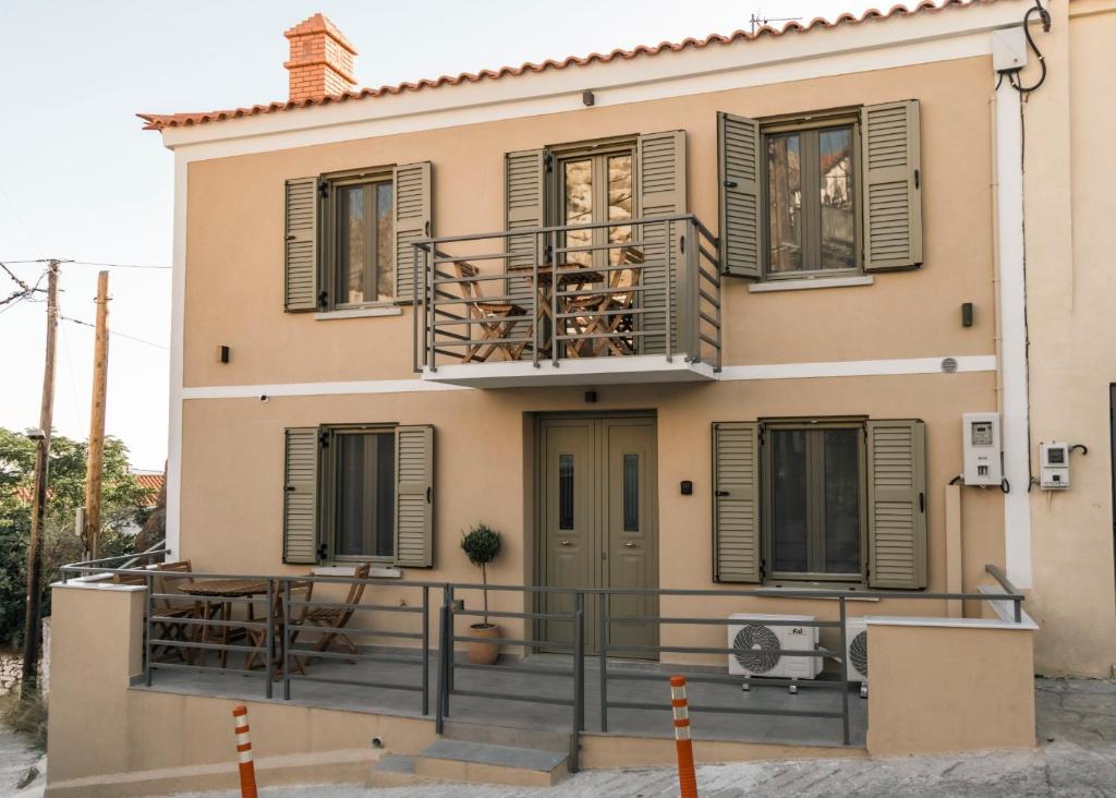 a house with a balcony with chairs and windows at Akrolithos apartments 1st floor in Platy