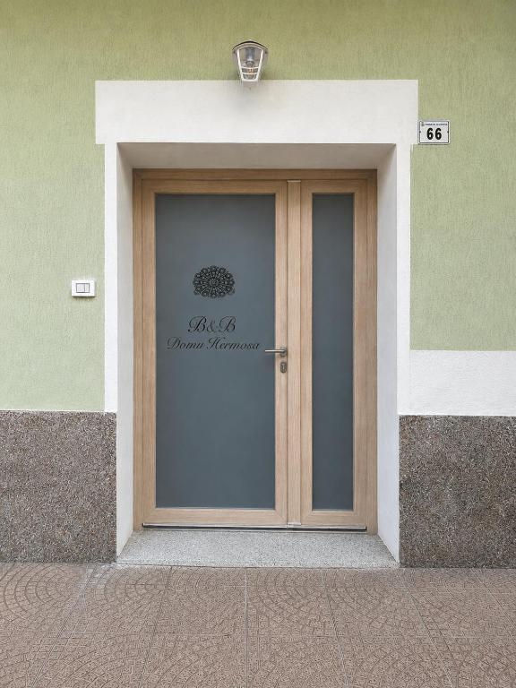 a door to a building with a sign on it at Domu hermosa in Villaputzu