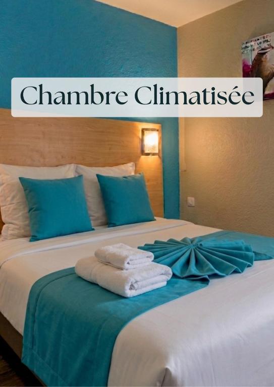 a bed with towels on it with a sign that reads chaminade clinic at The Originals Access, Hôtel Innostar in Labège