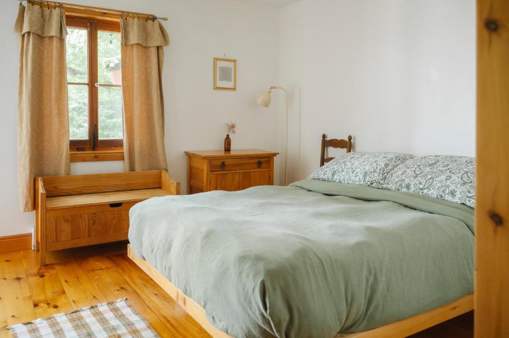 a bedroom with a bed and a desk and a window at Le Triangle de l'île - Chambre La Jardin in Saint-Laurent-de-l'ile d'Orleans