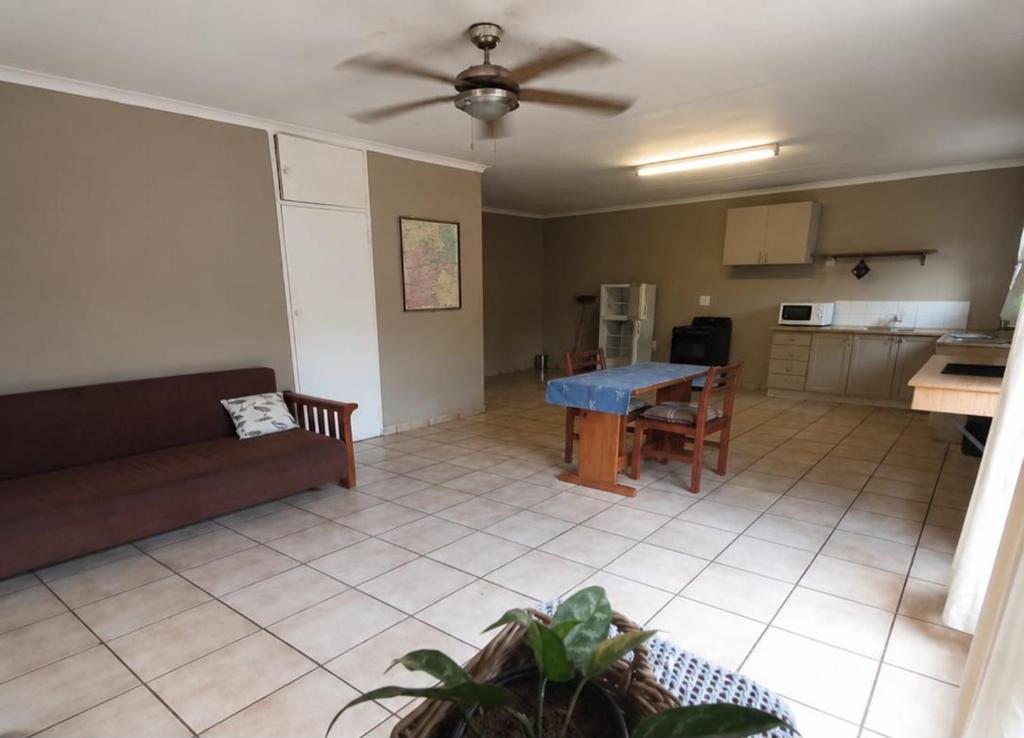 a living room with a couch and a table at Ligema Lodge in Malelane