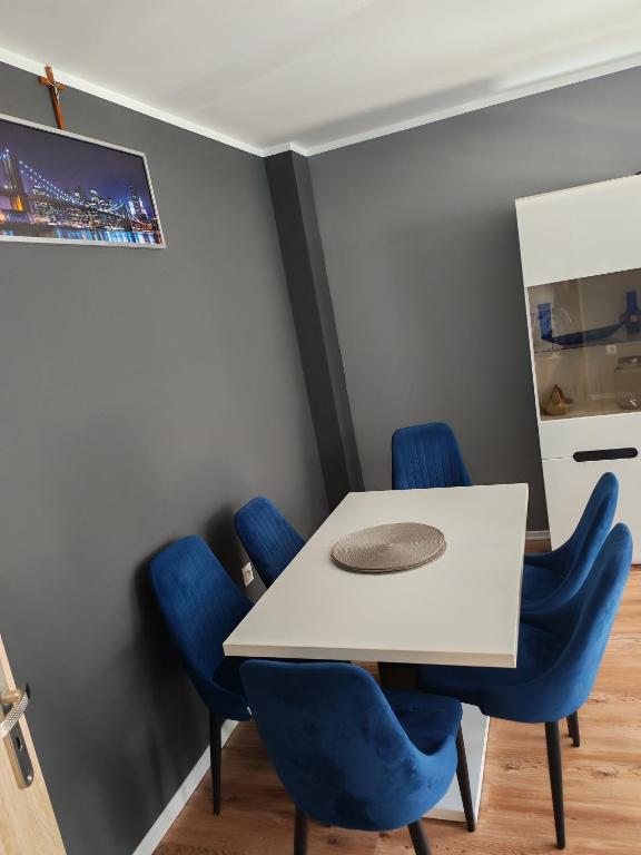 ein Besprechungsraum mit einem weißen Tisch und blauen Stühlen in der Unterkunft Potok in Walim