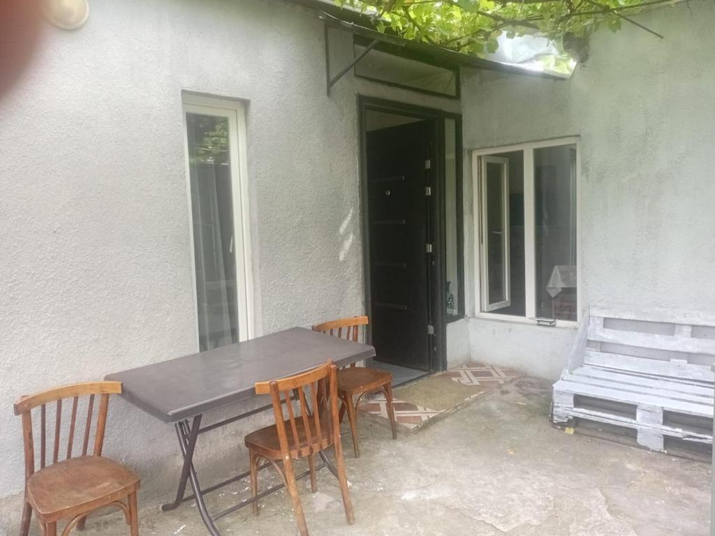 a table and chairs in front of a house at borjomi downtown in Borjomi