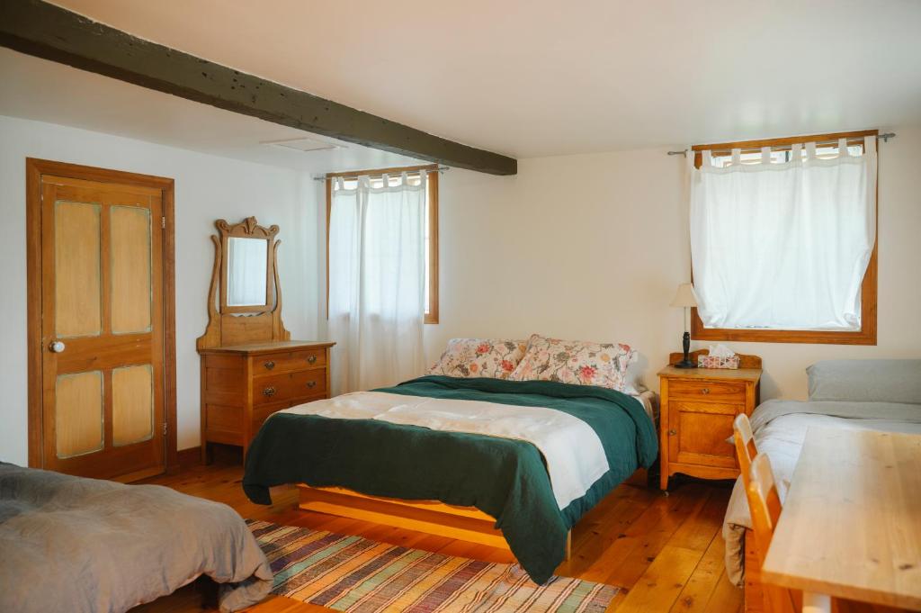 a bedroom with two beds and a mirror at Triangle de l'île Chambre Familiale in Saint-Laurent-de-l'ile d'Orleans