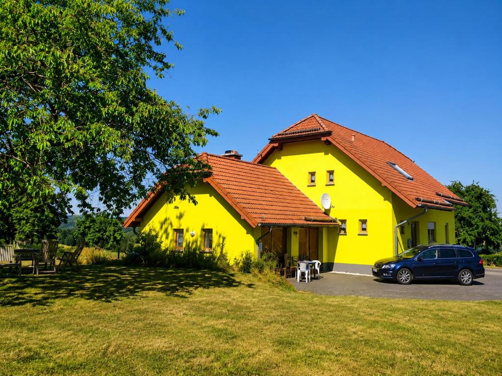 a yellow house with a car parked in front of it at Urlaub mit Hund auf dem Bauernhof Hofswald in Euscheid