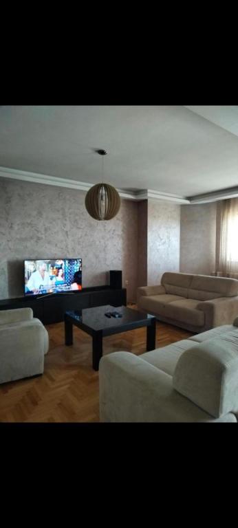 a living room with couches and a flat screen tv at Panorama View in Niš